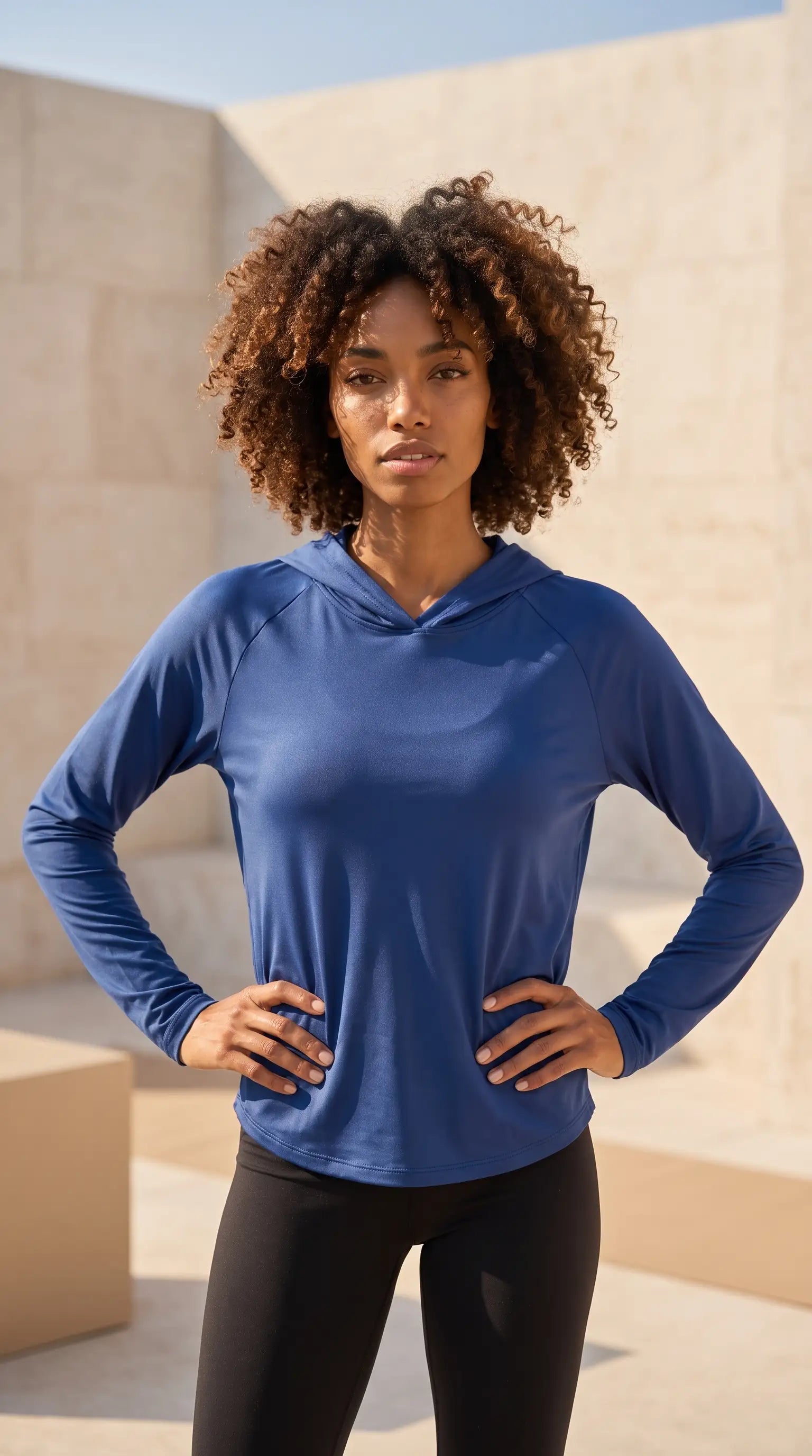 Woman wearing a Women's hooded sun protection running shirt, blue, with a relaxed fit, perfect for outdoor activities.
