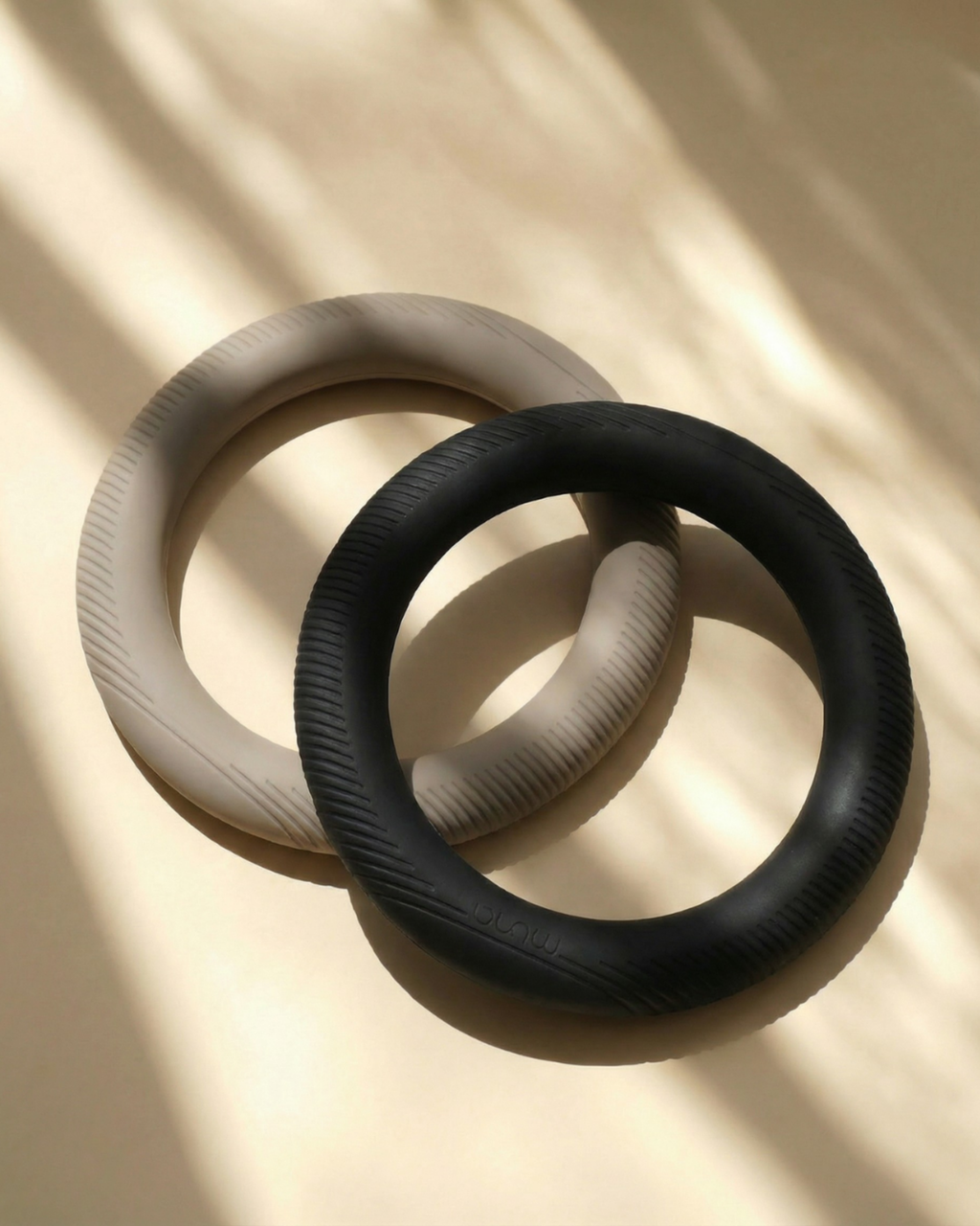 MUNA Dumbbell Ring, a ring-shaped dumbbell for home workouts, featuring a sleek design in black and beige.