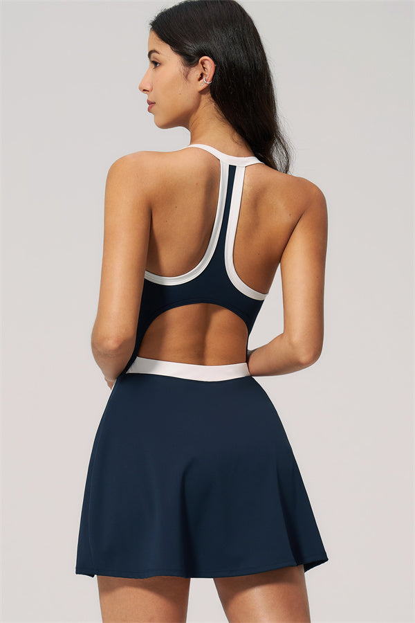 Model showcasing The New High End Spunk Tennis Dress in navy, highlighting its stylish racerback design.