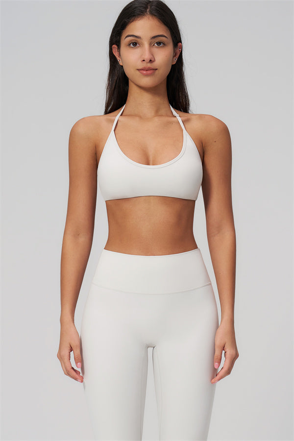 The Rapture Sports Bra Leggings 2-Piece Set featuring a model in a halter neckline sports bra and high-waisted leggings.