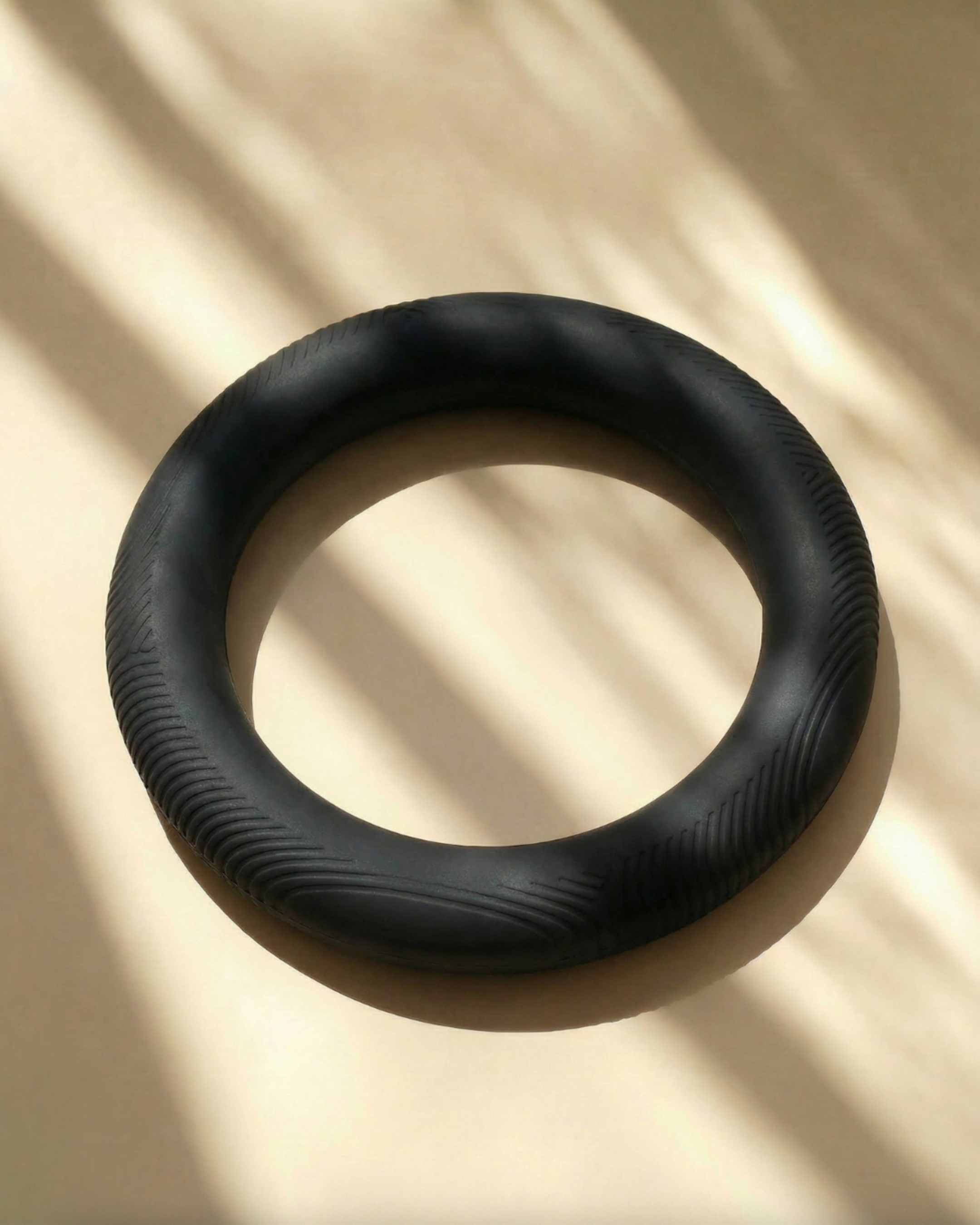MUNA ring-shaped dumbbell for home workouts resting on a light background, showcasing its sleek design.