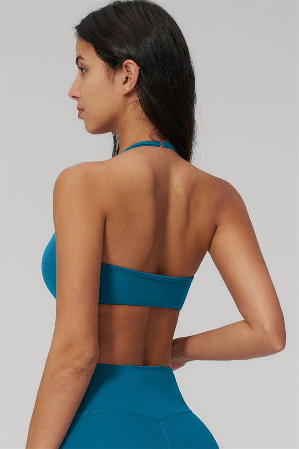 The Rapture Sports Bra Leggings 2-Piece Set model showcasing the back of the blue sports bra with halter neckline.
