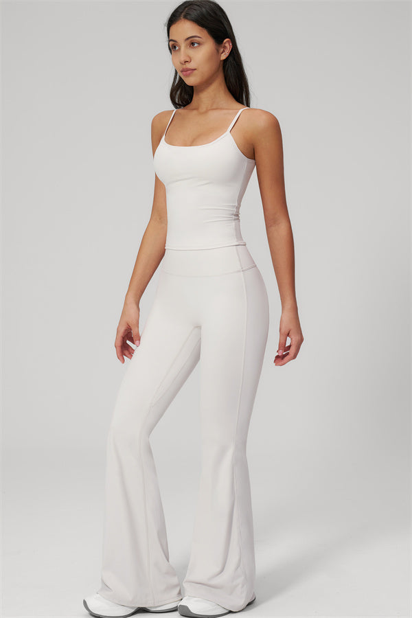 Model wearing The Rapture Tank Top Flared Leggings 2-Piece Set in white, showcasing a stylish and trendy outfit.