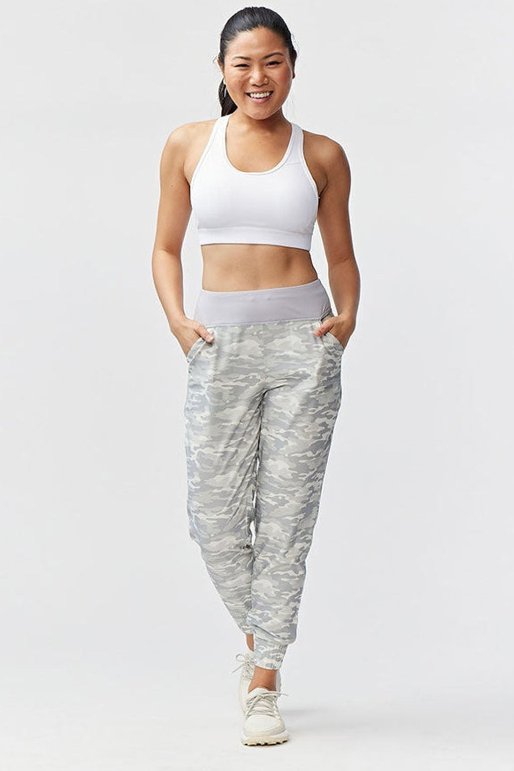 Excel Jogger 78 Length 28 Pant model wearing a gray camo jogger pant with pockets and a white sports bra.