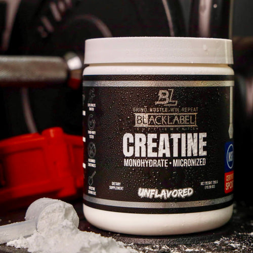 BLACK LABEL CREATINE MONOHYDRATE unflavored powder container next to gym equipment.