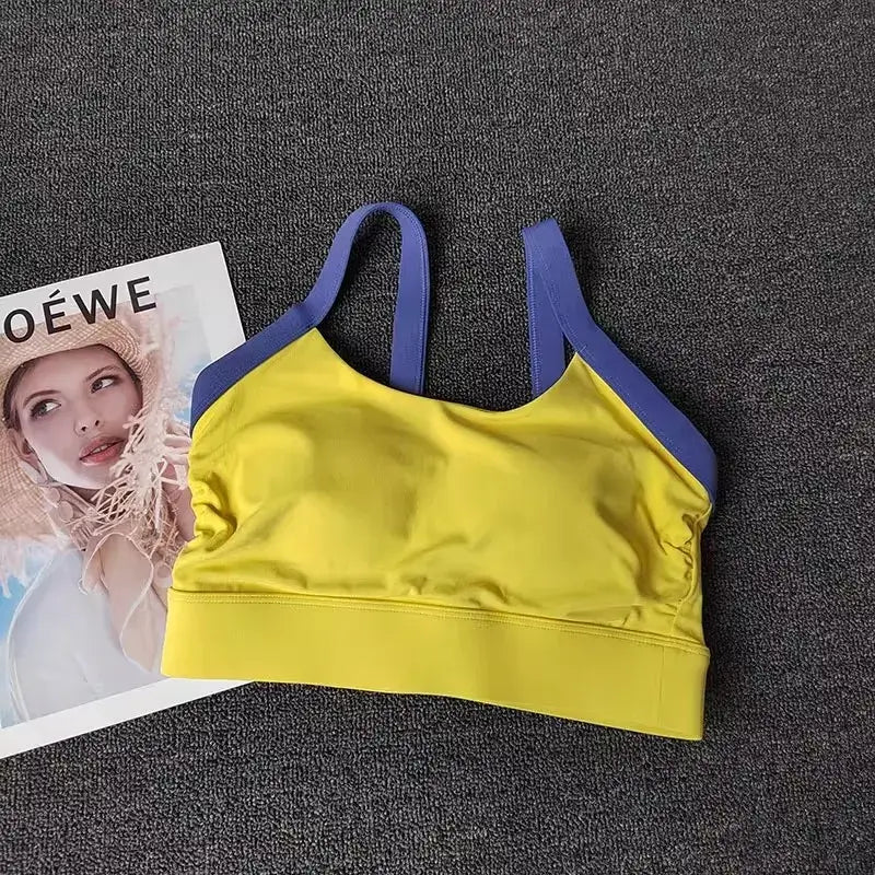 Women’s High-End Yoga Workout Set Yellow sports bra with blue straps on a textured surface next to a magazine