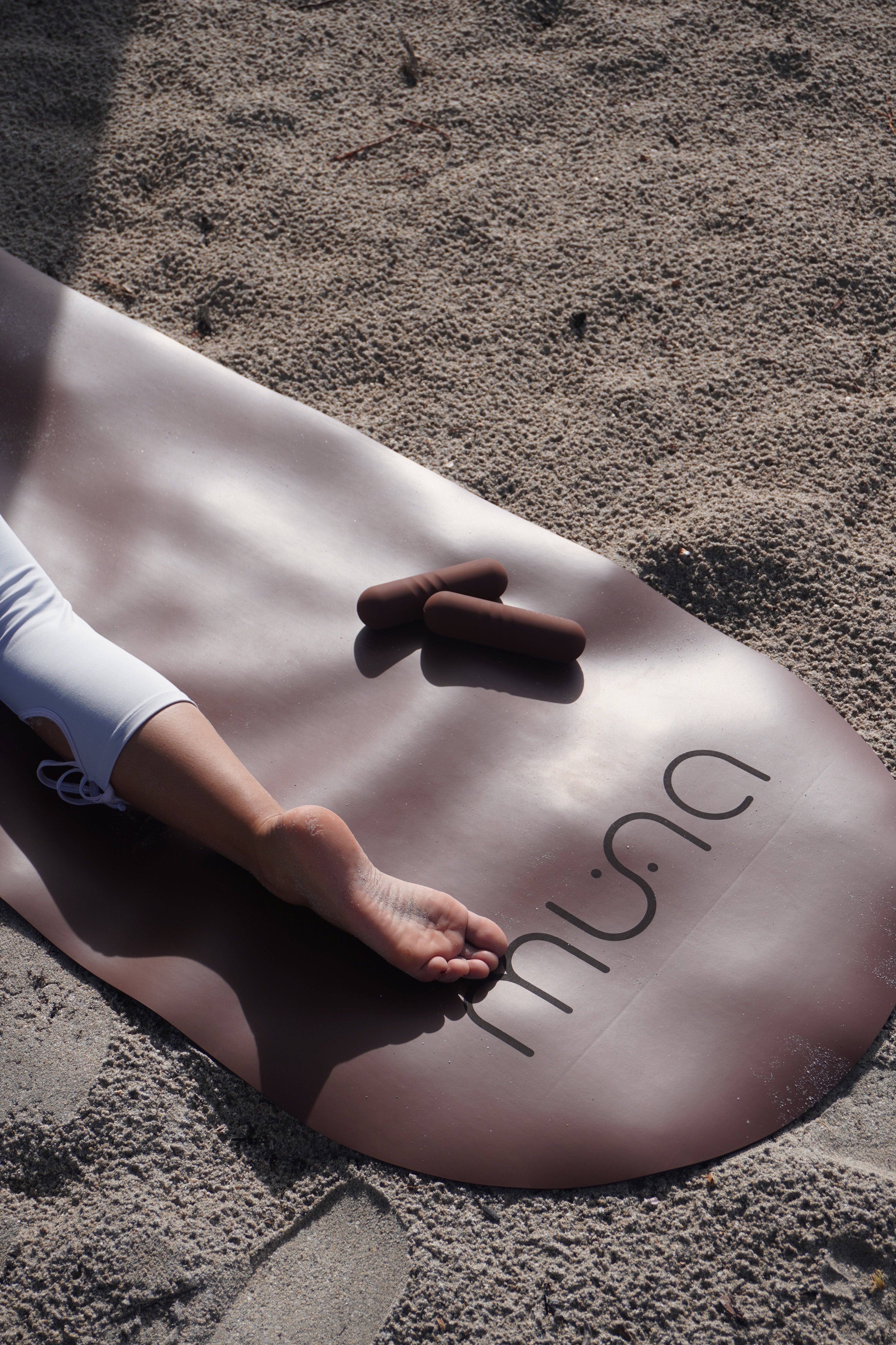 MUNA Oval Yoga Mat on sandy surface demonstrating oval yoga mat for non-slip performance during practice.