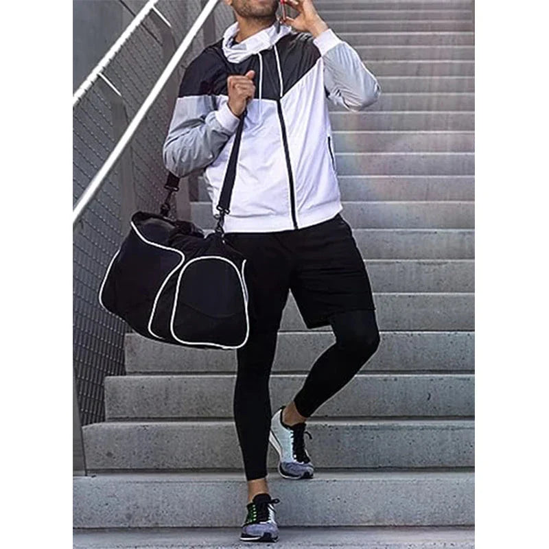 Man wearing Men’s 2-in-1 Quick-Dry Training Pants and athletic jacket, carrying a gym bag while walking down stairs.