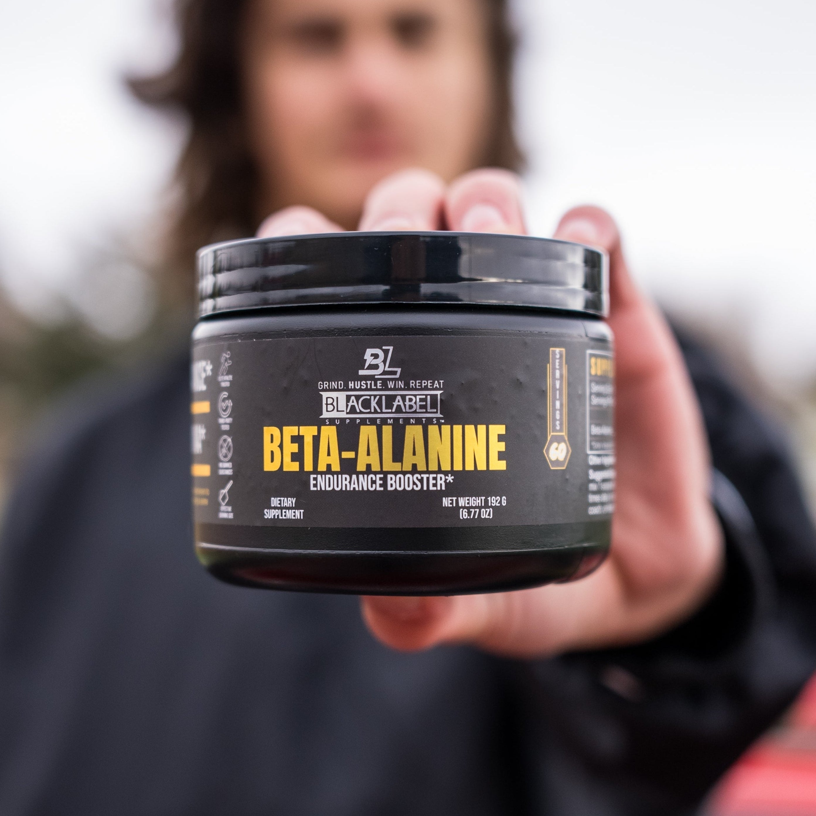 BETA ALANINE POWER FROM BLACKLABEL SUPPLEMENTS in a jar held by a person, promoting workout endurance and performance.