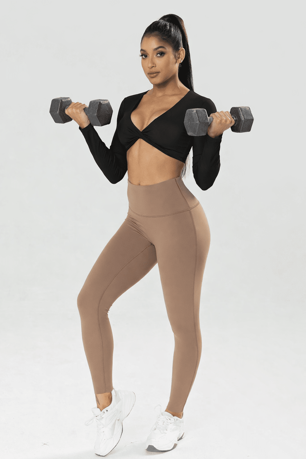 Blaire Sport Twist Knot Long Sleeve Workout Crop Top with Bra worn by a model holding dumbbells in a fitness setting.