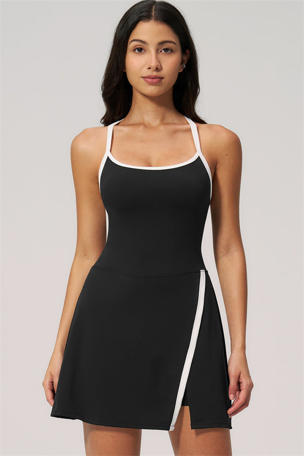 Model wearing The New High End Spunk Tennis Dress in black with stylish white accents, perfect for on-court performance.
